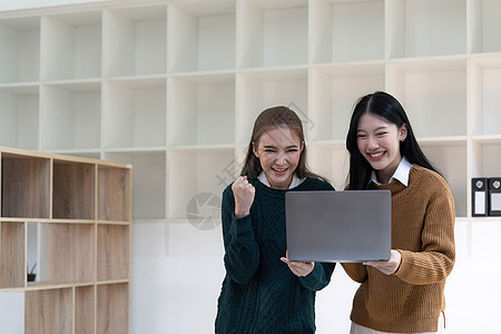 两名美丽的亚洲女商务人士利用数字平板电脑咨询和分析办公室工作的信息站立起来 她们站在办公室工作公司女性药片同事会议伙伴团队人士桌图片