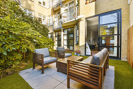 一个有沙发 椅子和桌椅的院子公寓植物装饰房子建筑学房间座位小地毯木头奢华图片