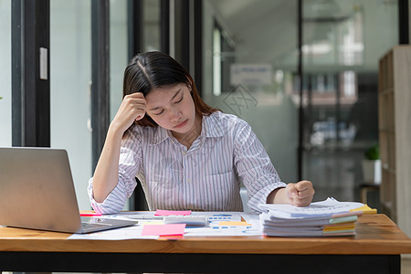 亚洲女性在办公室工作时遇到问题 同时在压力和头痛的情况下努力工作 女性努力工作的概念人士桌子商业商务女士员工挫折沮丧笔记本技术图片