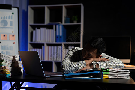 精疲力尽的商务人士睡在办公桌前 深夜加班 他被成堆的文书工作包围商务中小企业标志企业家职场办公室啤酒成人压力技术图片