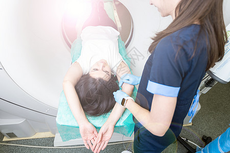 CT 扫描技术专家在准备手术过程中俯瞰计算机断层扫描仪中的患者 进入 CT 扫描仪的女病人治疗药品辐射技师射线女性核磁共振医院成图片