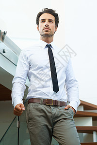 一个穿着西装的帅哥 站在楼梯上摆着姿势图片