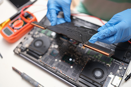 个人计算机修理技术员 配备关于硬件技术和计算机主机架背景的膝上型电脑图片