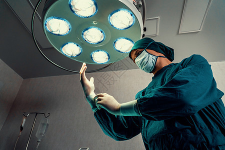 外科医生在手术前戴上防护外科消毒手套和面具情况操作治疗男人工作专家卫生医师医护人员安全图片