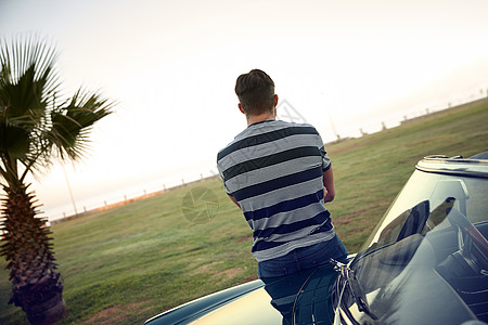 情况越来越好 一个男人仰着他的车看着风景的后视镜拍到一张照片图片