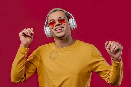 积极的人听音乐 在红色工作室背景下戴着耳机享受舞蹈 收音机 无线现代音响技术 在线播放器流动玩家互联网设备动机生活人脸模型学生成图片