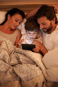 现代时代的童话故事 一个男孩躺在床上时用平板电脑拍了一张照片父母学习青年药片妻子互联网网站男人中年屏幕图片