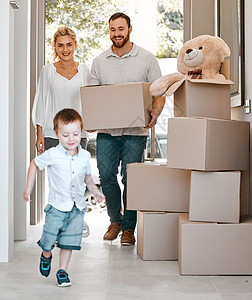 兴奋的小男孩跑进他的新家 幸福的家庭搬进新购买的房产 父亲提着箱子 搬进了他的房子 快乐的父母带着儿子搬进他们的房子图片
