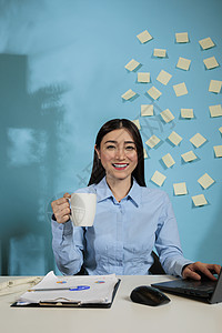 妇女坐在工作站上 喝着一杯咖啡图片