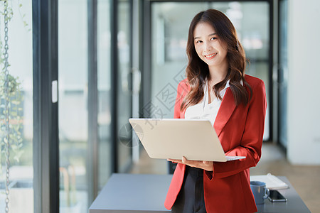 亚洲商业业主或亚洲女性销售商在办公室工作时使用平板电脑审计摄影技术自由职业者文书手机文档人士职业药片图片