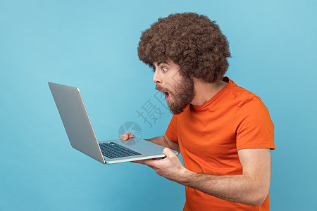 在笔记本电脑上做自由职业的人 在互联网上打字 看着笔记本电脑屏幕感到惊讶图片