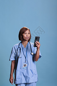 在网上视频通话中与远程医生交谈的手持移动电话的医生护理员图片