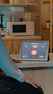 女人在家里看带有自动化照明系统的平板电脑灯泡控制经济屏幕女士互联网活力技术软件工具图片