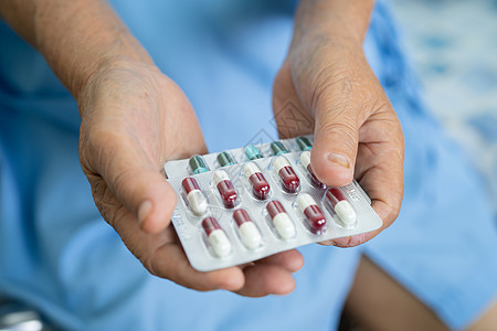 亚洲年长的老年老妇人手里拿着维他命C片药 健康有力的医学概念药物处方食物女士药店女性抗生素治疗帮助维生素图片