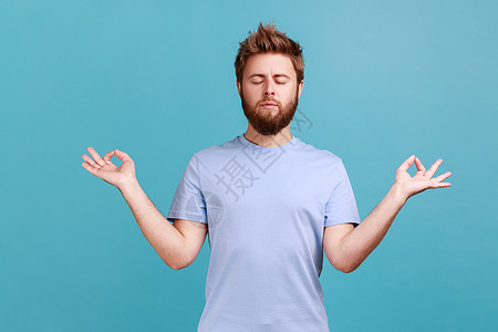 穿着T恤的人站着举起手 做瑜伽冥想练习 闭着眼睛图片