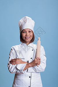 专业 专业和亚洲正面的厨师用手臂站在手交叉架着厨房滚针图片