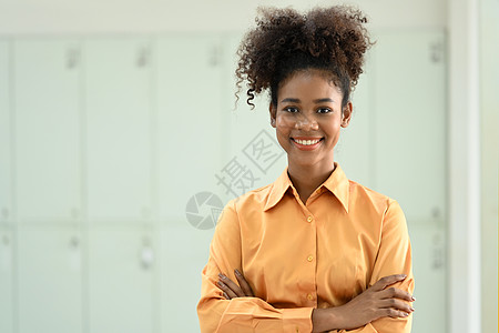 美国非洲女性雇员的肖像 站在十字手和笑着向镜头微笑的肩膀上图片