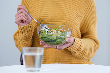 年轻漂亮的亚洲女人在吃沙拉 蔬菜 西红柿 卷心菜 生菜 黄瓜在桌上烹饪健康蔬菜沙拉 健康食品积极生活微笑厨房饮食女性幸福女孩午餐图片