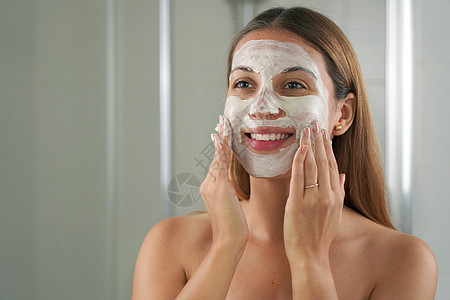 在浴室脸部戴粘土面罩的迷人女人近距离肖像净化清洁皮肤藻类女士女孩治疗滋润粉刺呵护图片
