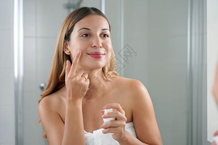 皮肤护理妇女 在浴室里涂奶油和抗视网醇抗信号剂血清化学女孩生物技术女士镜子剥皮滋润粉刺图片