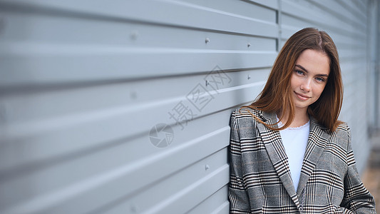 街上墙壁对着身穿衣的年轻女孩的肖像套装商业微笑黄色女性情绪女士西装街道人人图片