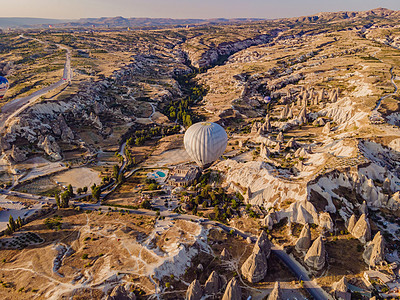 在土耳其卡帕多西亚州戈雷梅的Nevsehir仙子烟囱谷飞过 飞过有色热气球 对地下城市和气球旅游进行了惊人的全景无人驾驶飞机观察图片