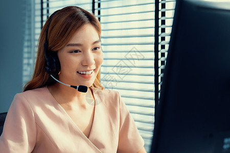 从事计算机工作和与客户交谈的合格女性经营者 三 职业妇女代理人服务台工人电话销售热线办公室女士数据助手服务图片