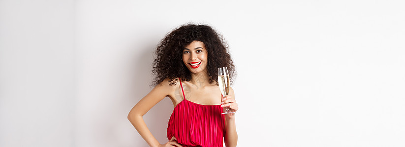 穿着优雅的红礼服 带着香槟杯装在白色背景上 在情人节有浪漫约会的情侣少女投标伙伴工作室女性浪漫情感惊喜男朋友周年展示图片