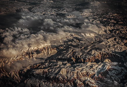 从山雪和山地风景的平面看空中阴影天空石头岩石阳光爬坡波浪天气顶峰环境图片