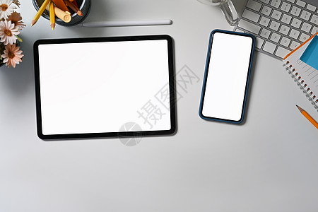 办公桌文具电脑白桌上的数字平板 智能电话和文具背景