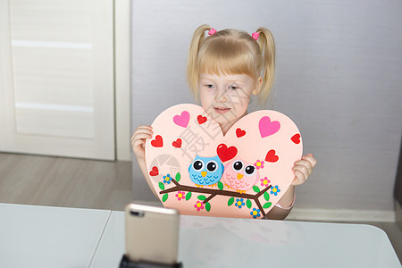 一位博客女孩以心灵的形状为情人节做了一种自觉的手工艺 儿童创造力和手工创作的概念 但是庆典假期夫妻卡片礼物工艺毛毡问候语爱好孩子图片