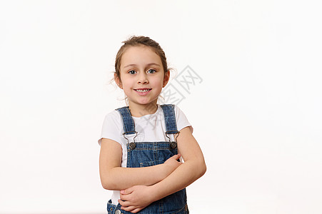 穿着蓝色牛仔服的可爱女婴的情感肖像 在白色背景上与副本广告空间隔绝图片