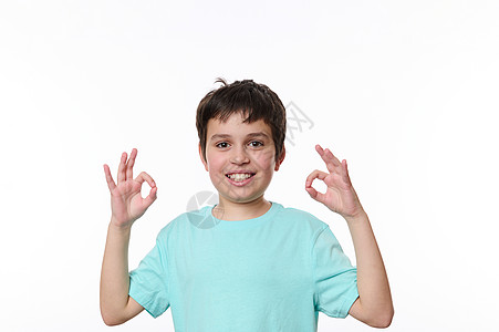 高加索快乐的男孩子在看镜头时展示了良好的标志 与白色背景隔绝 自由广告空间是免费的图片