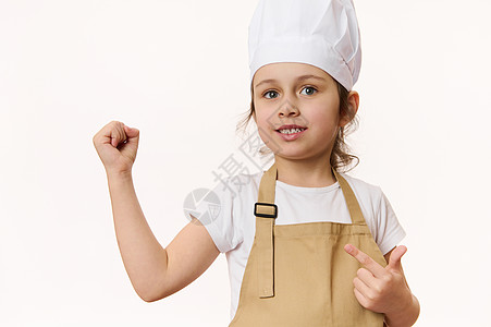 美丽的小女孩     围裙和帽子的厨师糕饼 在白种背景上孤立无遗 可免费提供宣传文稿空间图片