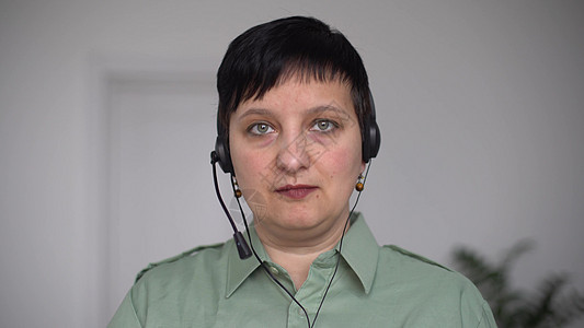 使用笔记本电脑在视频聊天时进行耳语对话中的妇女 COVID19大流行区自我孤立会议技术办公商业工作远程教育网络远程耳机屏幕图片