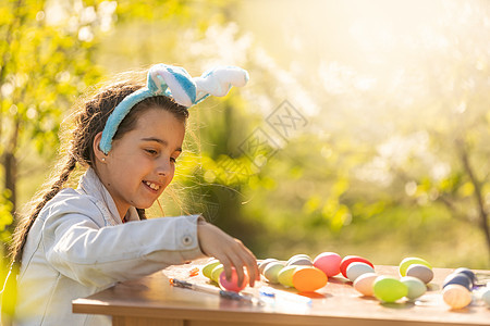 少女在花园里戴着复活节鸡蛋的兔子耳朵假期青少年节假期宝宝动物喜悦领结问候语家庭女孩图片