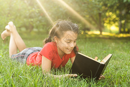 一本书在花园里的小女孩 孩子正在手上看书 夏日在户外 农村闲暇公园孩子们教育女孩女性魔法假期微笑学习图片