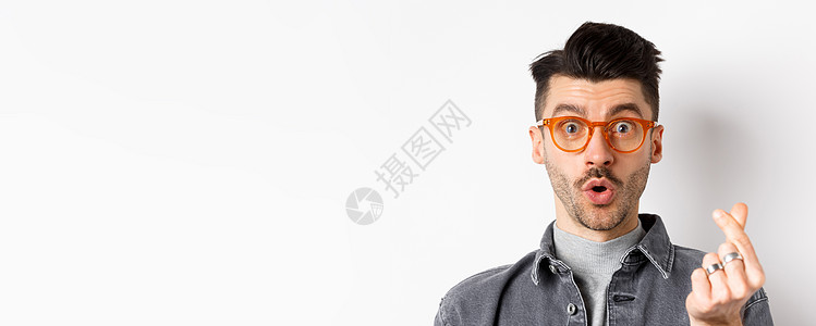贴近可爱家伙的肖像 长胡子戴眼镜 显示手心标志 看着镜头印象深刻 站在白色背景上广告商业夹克男人情绪成人眼镜发型工作室微笑图片