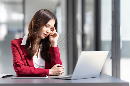 认真思考的亚洲女性关注在线问题解决方案 看着笔记本电脑屏幕 担心严肃的亚洲女商务人士专注于解决困难的工作计算机任务经济企业家金融图片