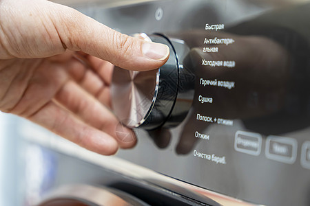 女人的手会用圆选择器选择洗衣方式学位垫圈家务控制板按钮工作洗涤浴室环境漂洗图片