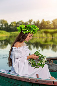深色头发长发的女神 穿着白色古董礼服 坐在河中央的一条船上女孩魅力美人鱼冒充裙子成人神话童话魔法若虫图片