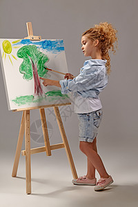 迷人的女学生正在用水彩刷画在壁架上 站在灰色背景上发型童年青年想像力绘画女性艺术生活活动创造力图片