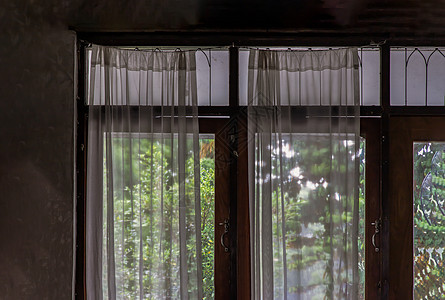 给传统泰屋的窗帘和白丝窗帘装上简单的木玻璃图片