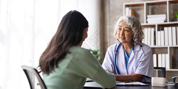 女高级医生正在阅读女病人的病史 并在诊所咨询期间与她交谈 身穿实验室大衣的医生坐在医院办公室的笔记本电脑后面治疗师微笑商业技术男图片