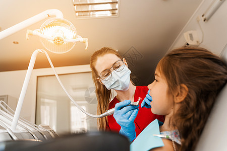 儿童牙医在牙科进行专业的牙齿清洁 牙科儿童牙齿的专业卫生 儿科牙医检查和咨询牙科儿童患者椅子治疗女孩考试药品病人专家工具女性女士图片