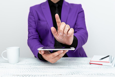 身穿紫色夹克的商务人士坐在桌旁 拿着手机 用一根手指指着重要信息 显示重要公告的绅士数位板职业商业套装电子邮件互联网商务成功触摸图片