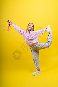 在演播室跳过绳子跳跃的可爱女孩童年孩子微笑工具训练跳绳运动装体操运动女性图片