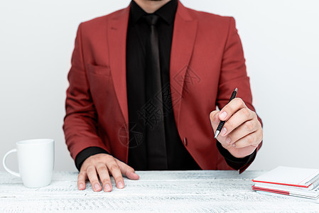 红西装男模特坐在白桌边 用笔指着重要信息 绅士们展示关键公告 咖啡杯在甲板上桌子成人公司套装金融电脑技术商务职业人手图片