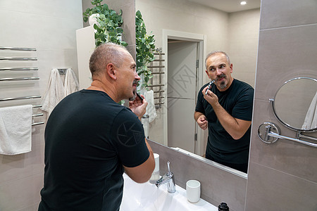 中年英俊男子在浴室刮胡子时剃胡子男性身体剃刀刮胡子头发家庭生活成人泡沫卫生皮肤图片