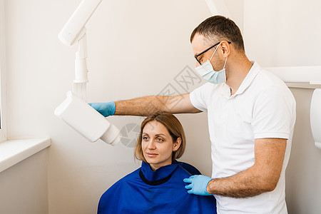 牙医为牙科女性进行 X 光牙齿扫描 用于检测牙痛和治疗牙根的牙齿 X 射线扫描全景医院机器保健放射科卫生扫描器矫正口腔科x射线图片